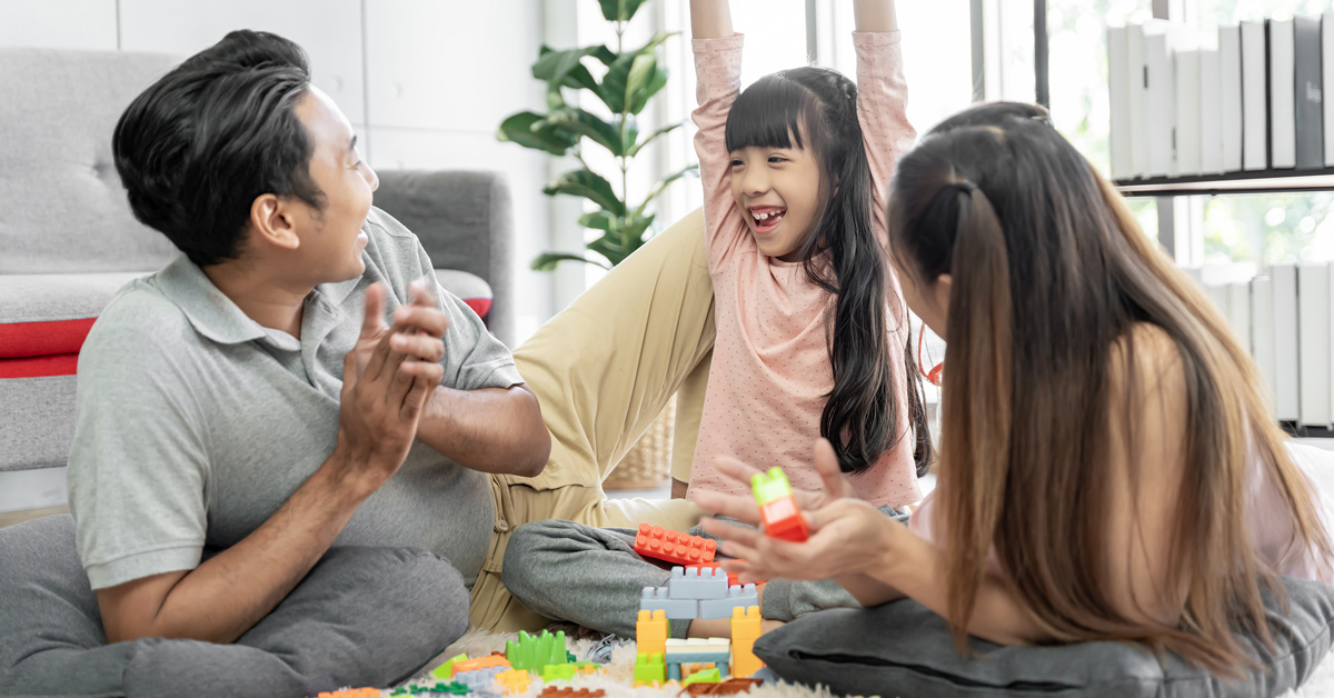 a-family-plays-with-toys-in-their-living-room A family plays with building blocks in their living room.